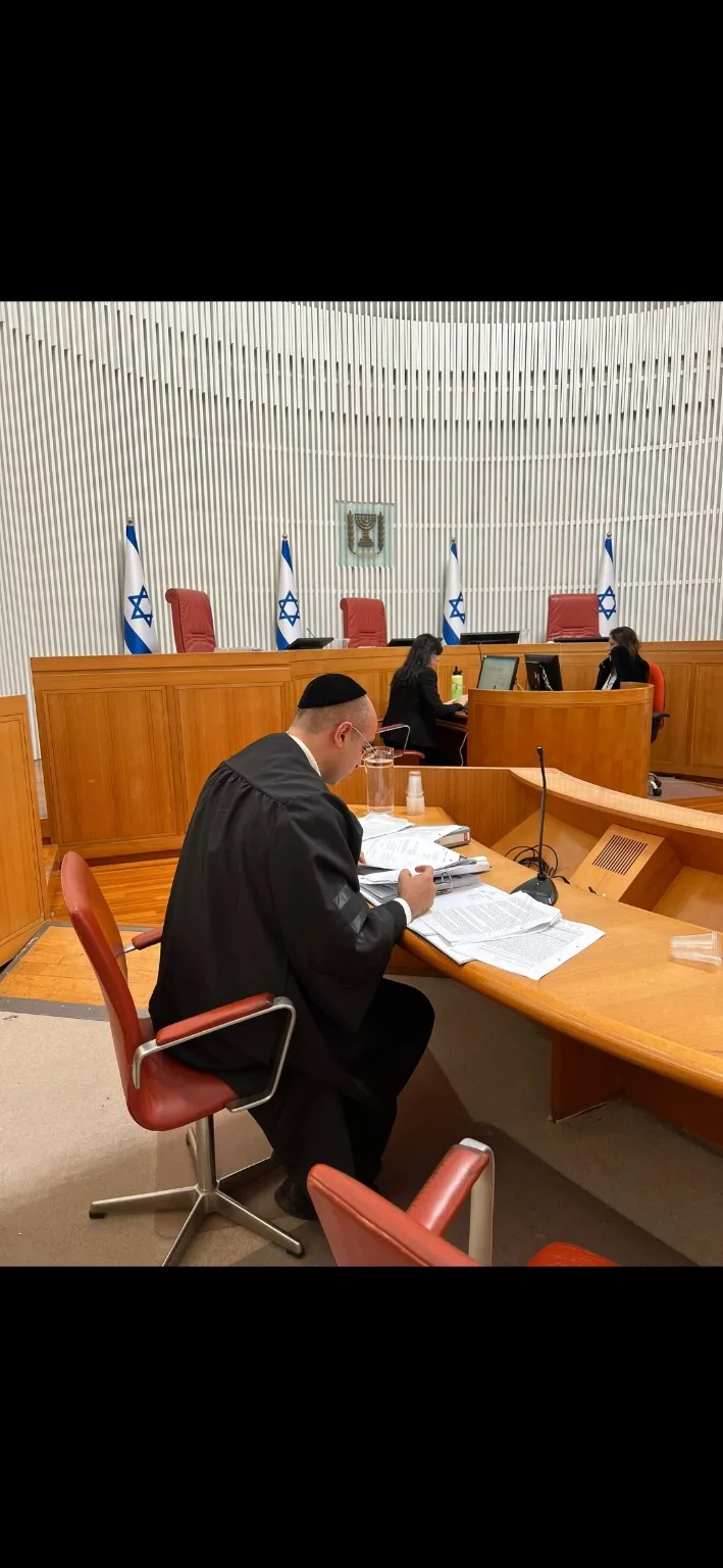 עו״ד ערן לוי אגמי מעיין במסמכי תיק באולם בית משפט